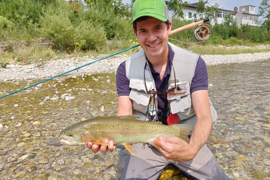 Ralf im Sommer mit einer Regenbogenforelle und Fliegenrute - Deutsche Traun Traunstein